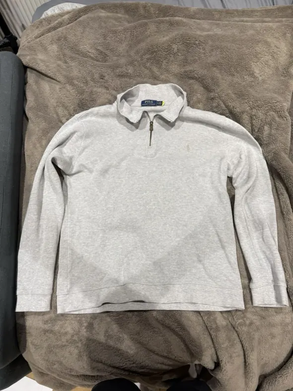 Before: a quarter zip photographed on a fleece blanket in dim indoor light