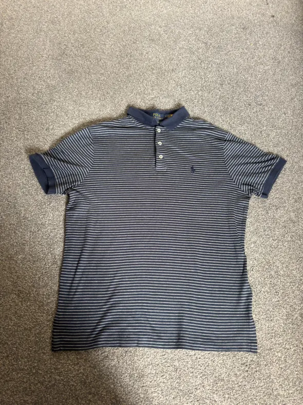 Before: a polo shirt photographed flat on a bedroom carpet in dull light